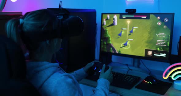 Young gamer girl playing at 3D game online using virtual reality headset