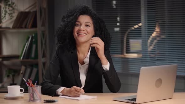 Portrait of African American Woman in a Business Suit Looking Away and Smiling