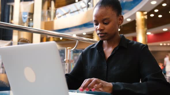 Excited Young Black Winner Woman Looking at Laptop Celebrating Internet Success While Sitting in