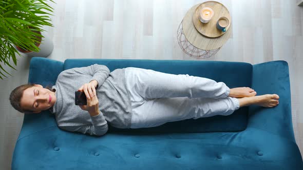 Overhead Shot of Happy Relaxed Woman Holding Smart Phone Using Mobile Apps Watching Funny Video