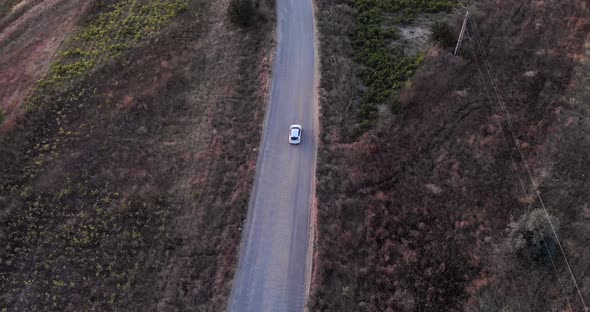 Aerial View Of A Car Driving On Road Near Macin Mountains