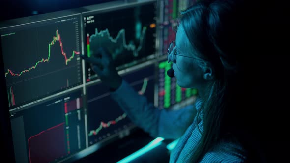 Trader is Working with Multiple Computer Screens with Charts and Data Analysis and Stock Broker
