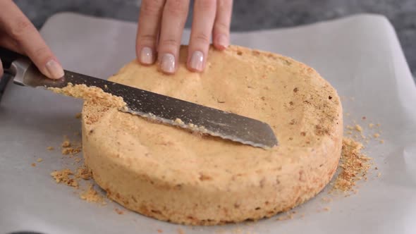 A housewife cutting a meringue nut layer cake. Making of Ukrainian Kiev Cake.