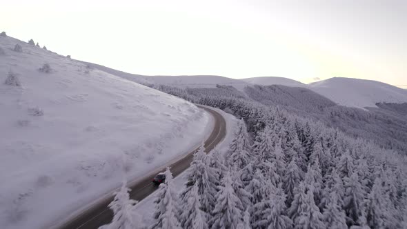 Chasing Black Car on Road to Mountain