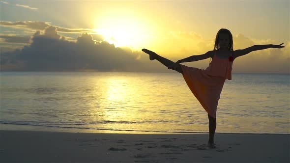 Silhouette of Adorable Little Girl on White Beach at Sunset. SLOW MOTION