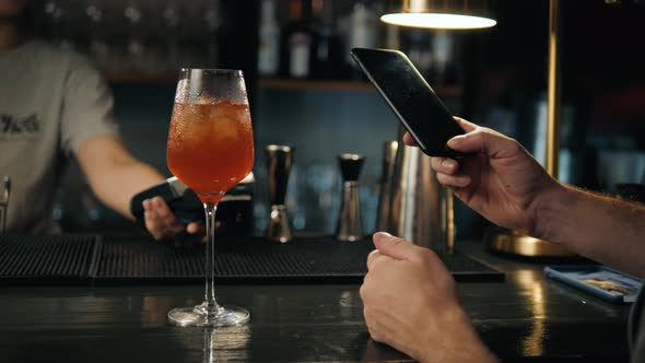 Closeup of Woman Making Payment Through NFC in Bakery Cafe Restaurant Bar for Cocktail Lemonade