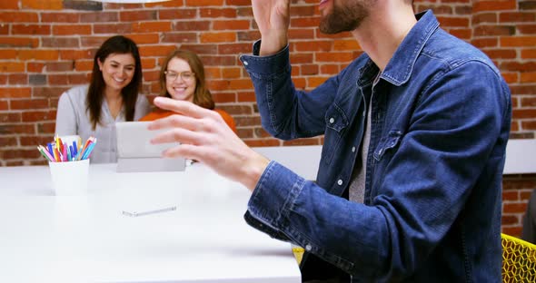 Male executive using virtual reality headset at desk