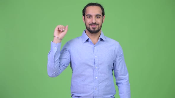 Young Happy Bearded Indian Businessman Pointing Up