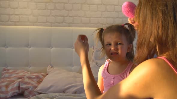 Mom With Daughter At Home On The Bed