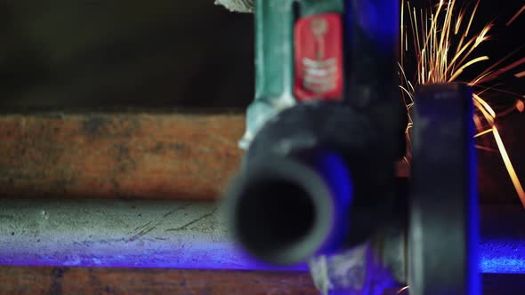 Professional Male Worker Cuts Off Metal Pipe with Grinder Clamping Them in Vise