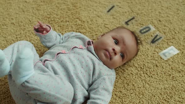 Adorable Infant Girl Lying on Carpet