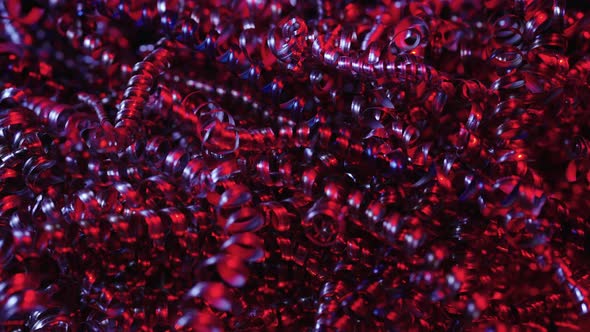 Camera Pans Along Shiny Metal Shavings Illuminated By Red Neon Lights