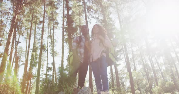 Smiling diverse couple looking away and hiking in countryside