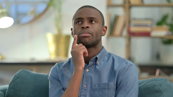 Pensive Young African Man Thinking at Home