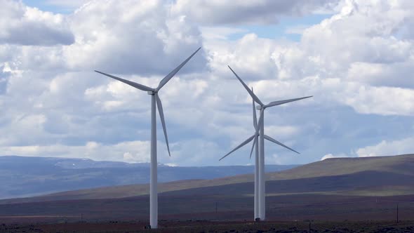 Wind mills spinning across grassy plains