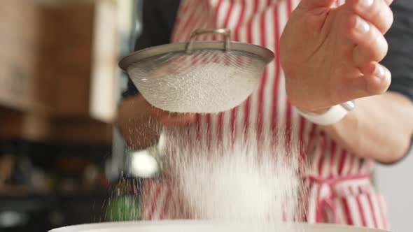 Woman Baker Sifting Flour for Dough Through Bolter