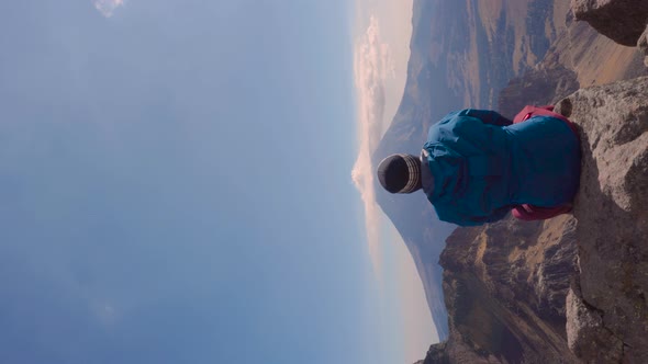 Young man sitting on the edge of a cliff