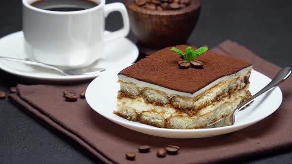 Portion of Traditional Italian Tiramisu dessert, cup of espresso coffee and coffee beans