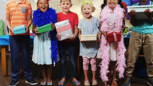 Portrait of kids holding gift boxes during birthday party 4k