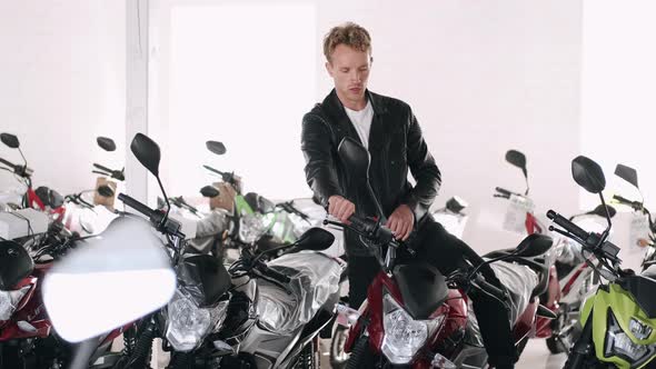 Young Man Choosing Motorbike at a Shop