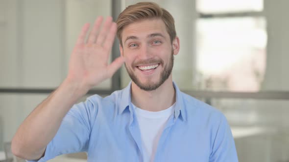 Portrait of Young Creative Man Waving Welcoming