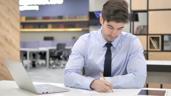 Businessman Writing at Work, Paperwork