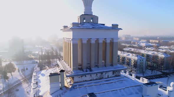 Tower with Columns and Spire on Snowy Roof of Old Building