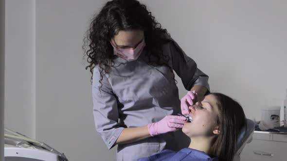 Orthodontist using dental impression tray on woman teeth