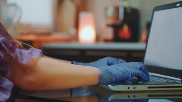 Close-up of Woman's Hands in Medical Gloves Typing on Keyboard