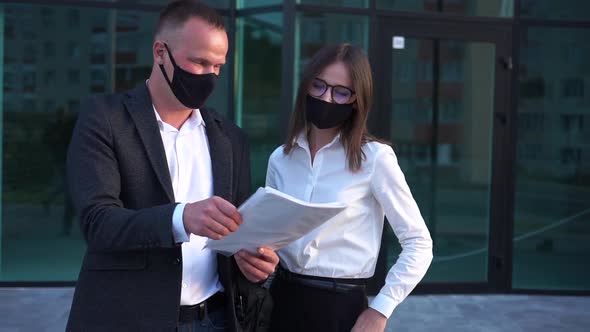 A Woman and a Man Work with Papers During a Pandemic