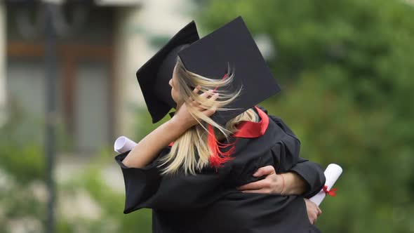 Happy Couple of Graduates, Handsome Man Embracing and Spinning Beautiful Woman