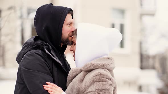 Beautiful Man and Woman in the Winter on the Street Froze and Put on Hoods