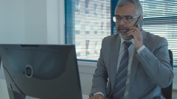 Focused Grey Haired Executive Using Computer