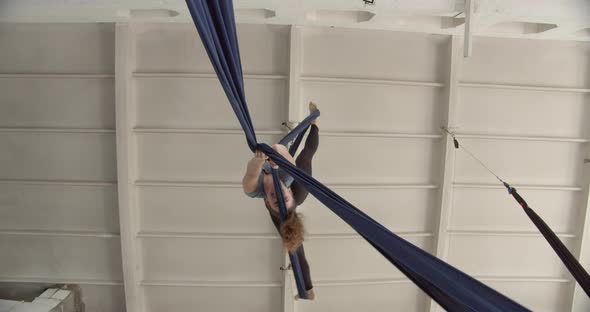 View From the Ground on a Woman Hanging in the Air on Fabric Doing Gymnastics