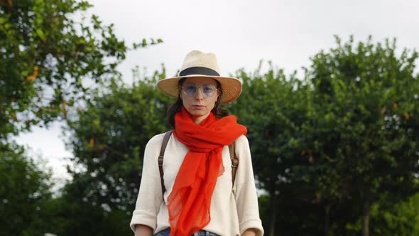 Attractive woman with red scarf looking at camera, outdoors