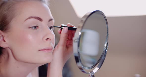 Woman Doing Makeup Painting Eyelashes with Mascara