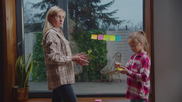 Cute Daughter Giving Task To Surprised Mother at Home