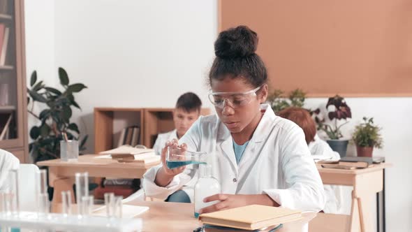 Smart Schoolgirl Doing Experiment in Science Class