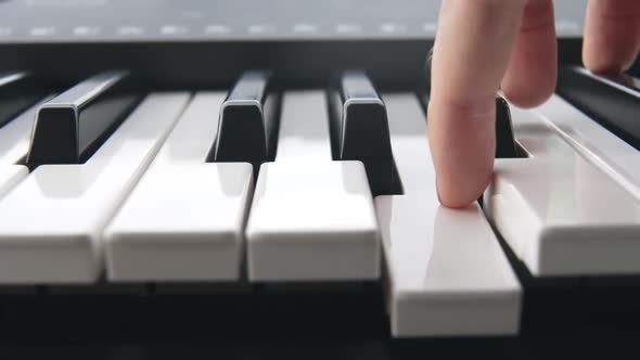 Closeup of the Fingers of a Man with a Pink Manicure Playing an Electronic Synthesizer