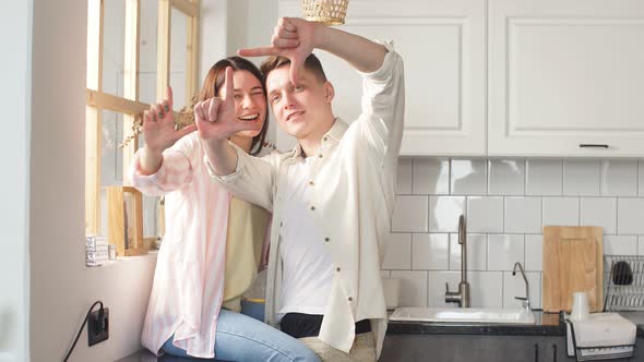 Young Attractive Woman and Handsome Man Pretending That They Are Making Photos