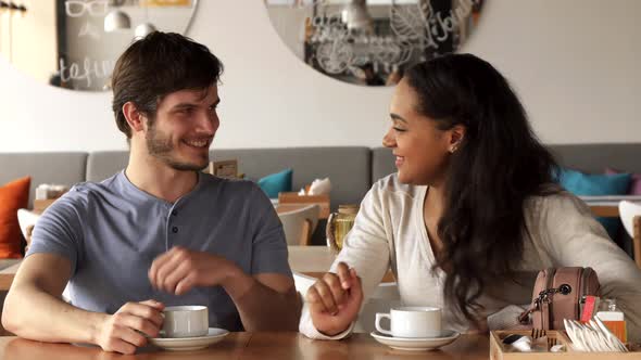 Girl Flirts with Her Male Friend at the Cafe