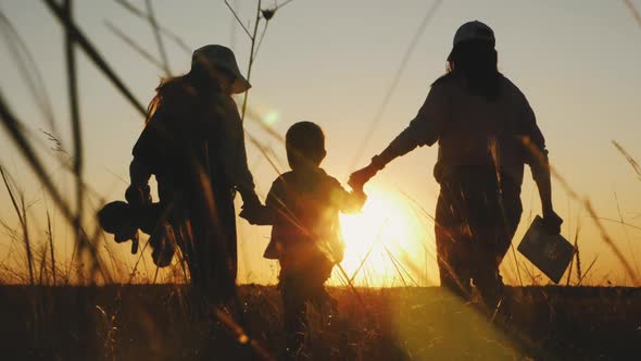 Happy Family Mom and Children Silhouettes Playing on Park