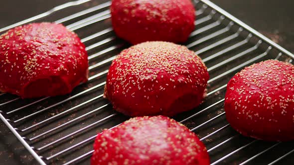 Fresh Baked Red Homemade Burger Buns with Sesame Top View. Placed on Metal Grill.
