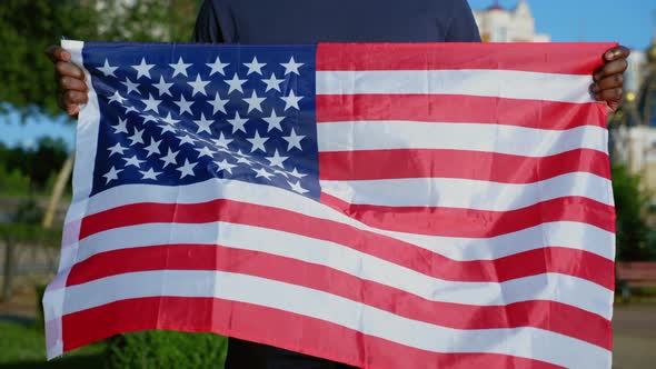 Close Up AfroAmerican Man Stands in Park with USA Flag in Summer