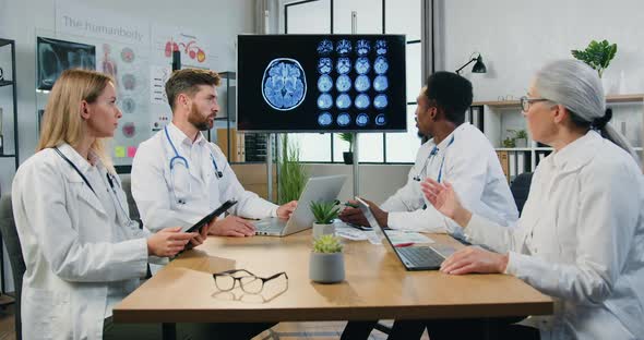 Team of Neurologists Holding Joint Meeting in Medical Office About Patient's Treatment