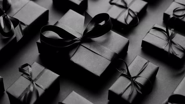 Elegant Black Christmas Theme. Wrapped Gifts in Black Matte Paper with Ribbon