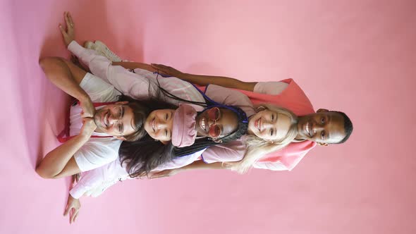 Portrait of Young Diverse People Leaned on Each Other Isolated on Pink Background.