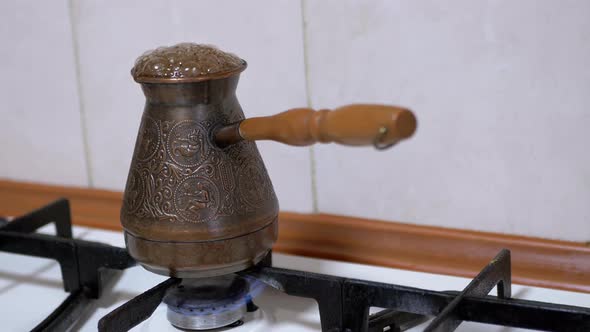 Preparing Ground Turkish Coffee in a Copper Turk on a Gas Stove