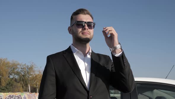 Male Businessman Takes Off Sunglasses