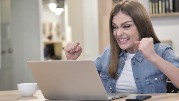 Creative Woman Celebrating Success While Working on Laptop